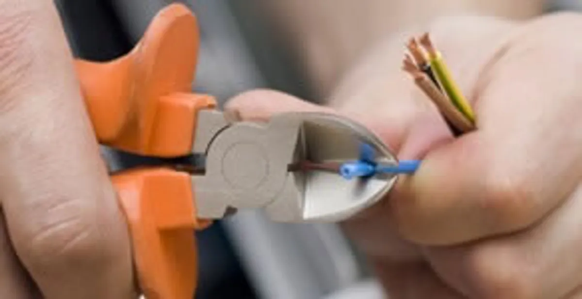 licensed electrician performing precise wire cutting and preparation during electrical service in Denver, CO